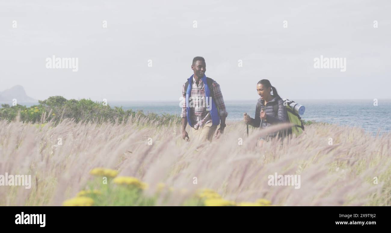 Bild vom Text des Unabhängigkeitstags über lächelnde, vielfältige Paarwanderungen Stockfoto