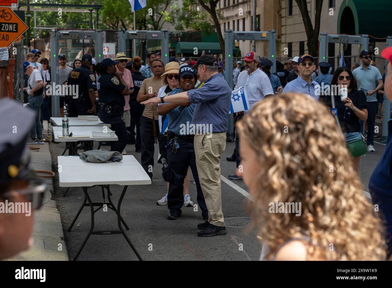 NEW YORK, NEW YORK - 02. JUNI: Zuschauer gehen während der jährlichen Feiern-Israel-Parade am 2. Juni 2024 in New York City durch den Sicherheitskontrollpunkt Enhanced NYPD. Zehntausende von Menschen marschierten während einer Parade für Israel auf die Fünfte Avenue, wobei viele zur Freilassung von Geiseln, die von der Hamas in Gaza festgehalten wurden, aufriefen: "Bring sie nach Hause", eine Botschaft, die laut und deutlich ertönte. Die Parade fand fast acht Monate nach dem beispiellosen Angriff der Hamas am 7. Oktober statt, dem tödlichsten in der Geschichte Israels. Die NYPD erhöhte die Sicherheit für die Parade aufgrund von Spannungen und Protesten rund um den Krieg in Gaza. Stockfoto