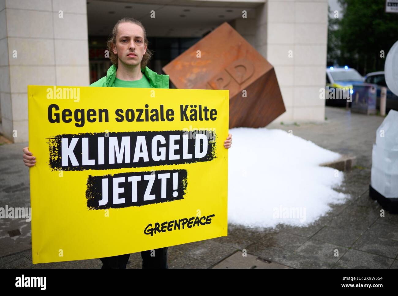 Berlin, Deutschland. Juni 2024. Ein Aktivist hält ein Schild mit der Aufschrift "gegen soziale Kälte - Klimageld jetzt!" Während einer Protestaktion der Umweltschutzorganisation Greenpeace vor dem SPD-Hauptquartier. Greenpeace-Aktivisten gossen etwa eine Tonne Eis vor dem SPD-Hauptquartier in Kreuzberg aus und errichteten ein gefrorenes S aus dem SPD-Logo, um für die Einführung des Klimageldes zu demonstrieren. Quelle: Bernd von Jutrczenka/dpa/Alamy Live News Stockfoto