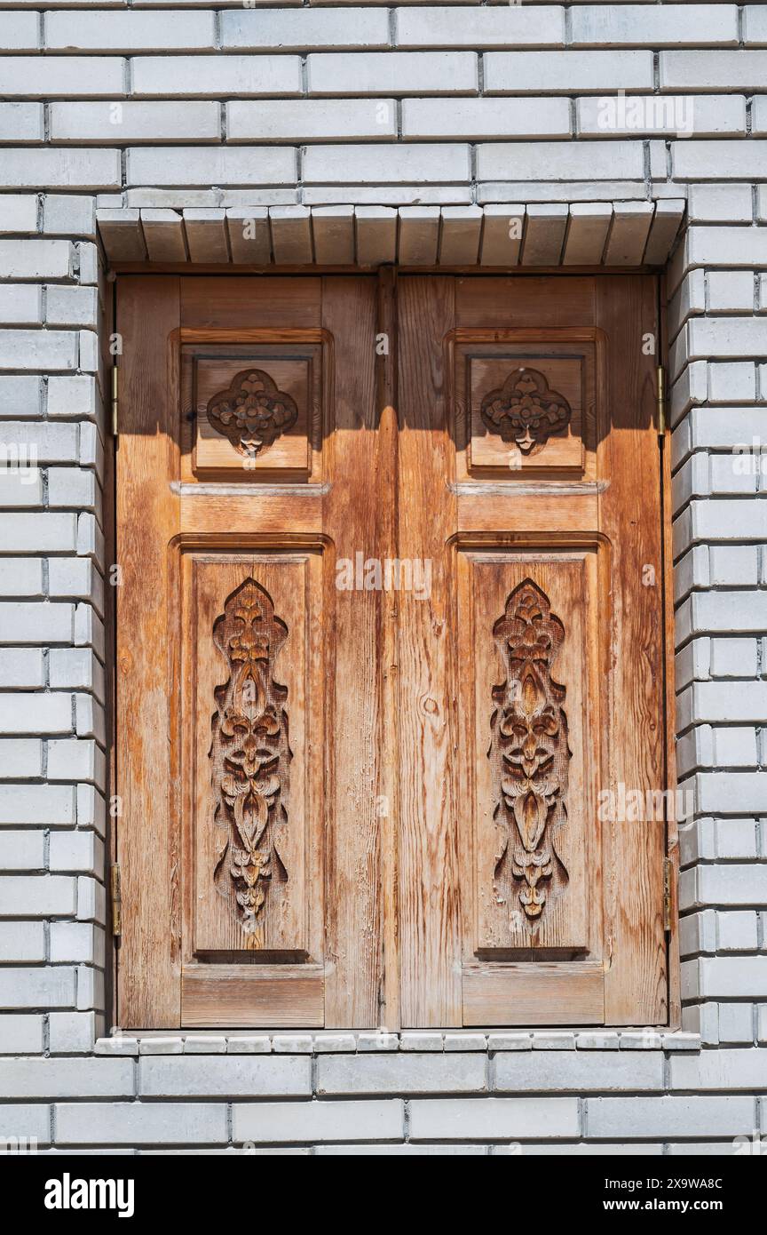 Hölzerne Fensterläden am Fenster mit orientalischem usbekischen Schnitzmuster verzierte Ornamente in Usbekistan in Taschkent Stockfoto