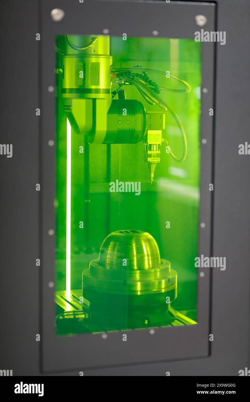 CNC-Maschine für Rotationsfaser-Laserbeschriftung. Nahansicht durch grüne Sicherheitstür aus Glas. Selektiver Fokus. Stockfoto
