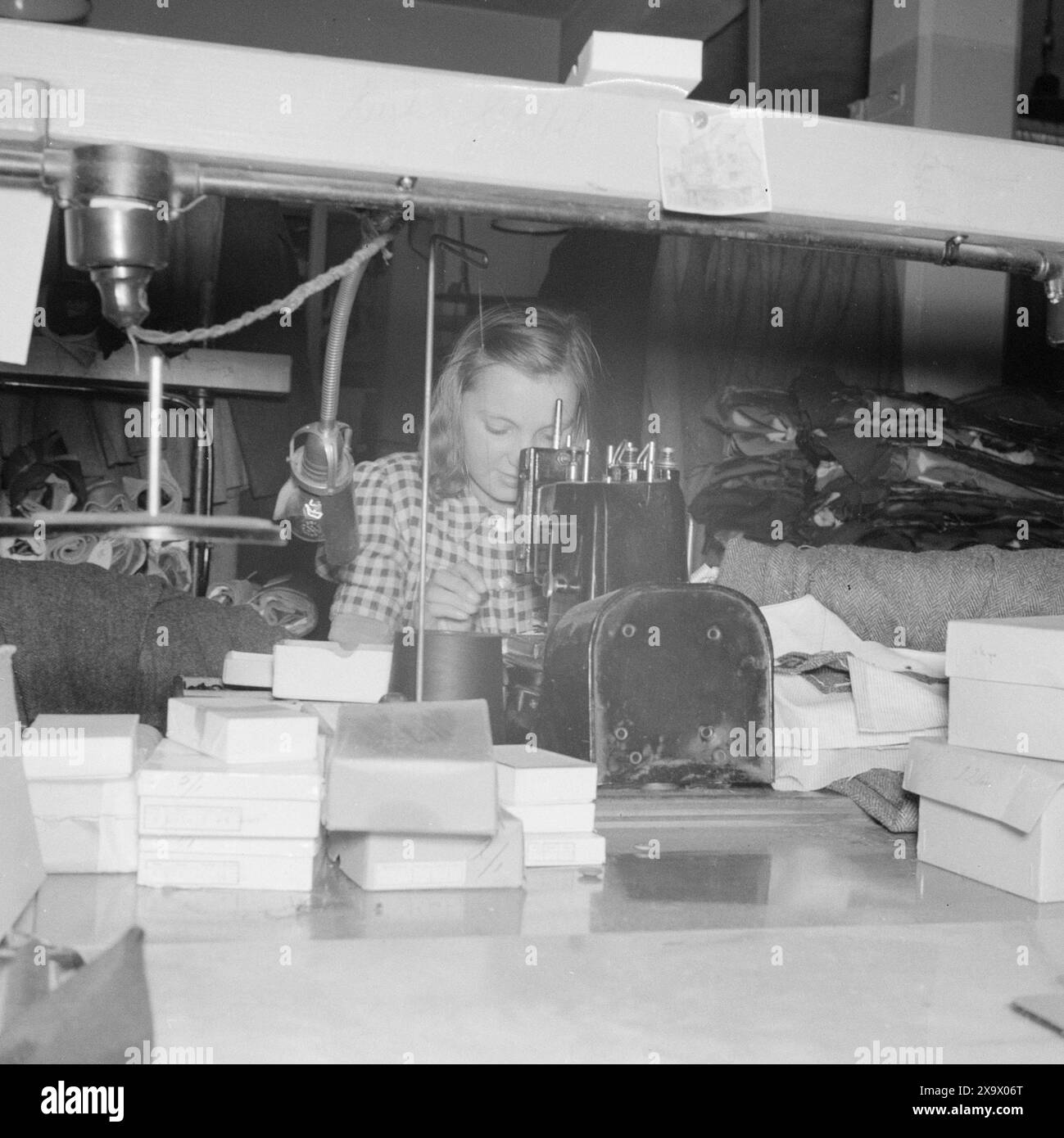 Tatsächlich 11 - 1945: Jetzt kommen die neuen Kleider. Bei Norske Konfektionsfabriker A/S. Das eigentliche Nähen von Knöpfen und das Anfertigen von Knopflöchern erfolgt mit Hilfe von genialen Maschinen, die sehr schnell und präzise arbeiten. Foto: Leif Ørnelund / aktuell / NTB ***Foto ist nicht bildverarbeitet*** Stockfoto