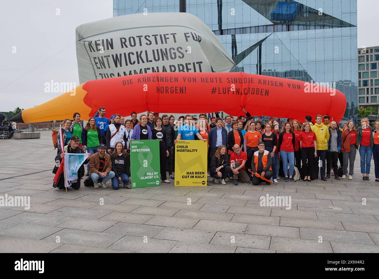 Mit einem zwoelf Meter langen Rotstift hat ein Buendnis aus zivilgesellschaftlichen Organisationen am Montag 03.06.2024 vor dem Berliner Hauptbahnhof gegen geplante Einsparungen bei Entwicklungspolitik und humanitaerer Hilfe protestiert. Foto: Mitglieder von Save the Children, der Verband Entwicklungspolitik und Humanitaere Hilfe VENRO, Oxfam, The ONE Campaign der Arbeiterwohlfahrt und andere Kuerzungen seien angesichts der weltweiten Herausforderungen der falschen Weg, kritisierte das Buendnis im Rahmen der Kampagne LuftNachOben am Montag bei der Aktion. Siehe epd-Meldung vom 03.06.2024 EDITOR Stockfoto