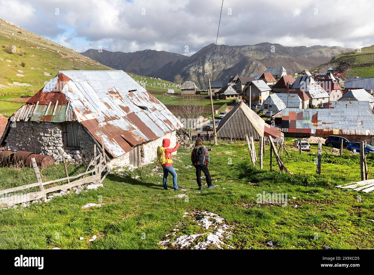 Mutter und Sohn, Touristen auf einem Familienausflug, die traditionelle Häuser im Bergdorf Lukomir in Bosnien und Herzegowina erkunden. Stockfoto
