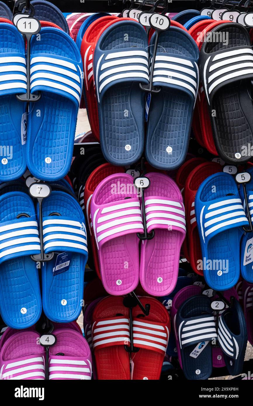 Farbenfrohe Strandsandalen auf einem Gestell in Cornwall im Vereinigten Königreich. Stockfoto