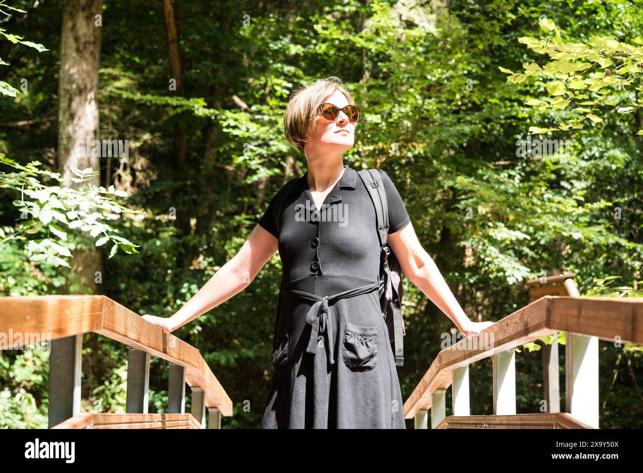 Porträt einer Frau an einer Holzbrücke über ein kleines Bachtal im Wald, Kordel, Deutschland. Modell freigegeben Stockfoto