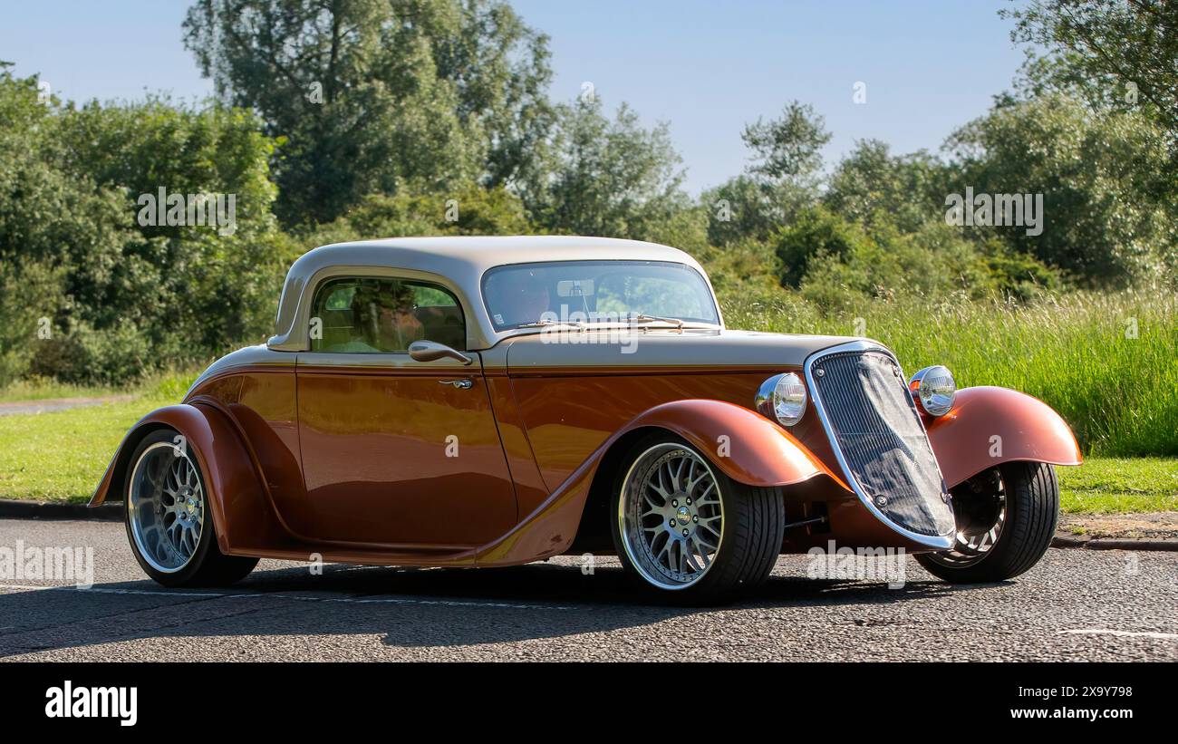 Stony Stratford, UK - 2. Juni 2024: 2011 Orange Factory Five Racing '33 Hot-Rod V8 amerikanisches Nachbau-Kit-Auto, das auf einer britischen Landstraße fährt Stockfoto