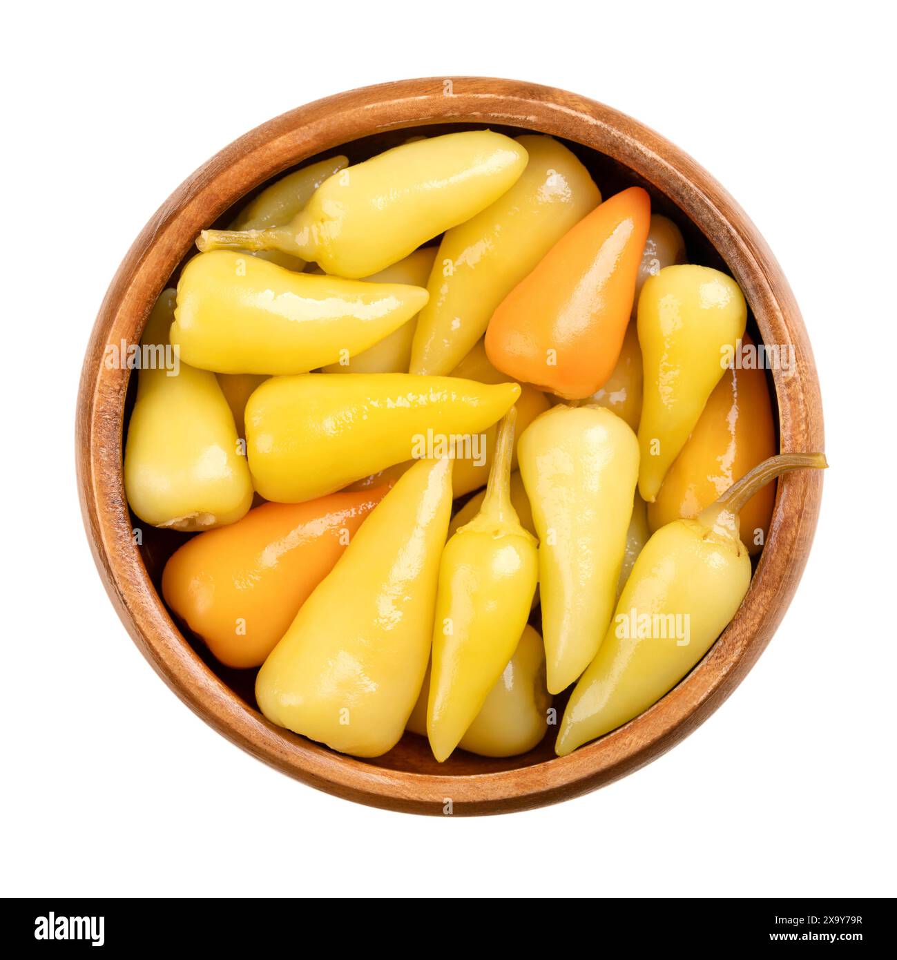 Eingelegte gelbe, heiße Paprika in einer Holzschale. Kleine heiße Chilis, Paprika oder Paprika, pasteurisiert und in einer Essigsalze haltbar gemacht. Stockfoto