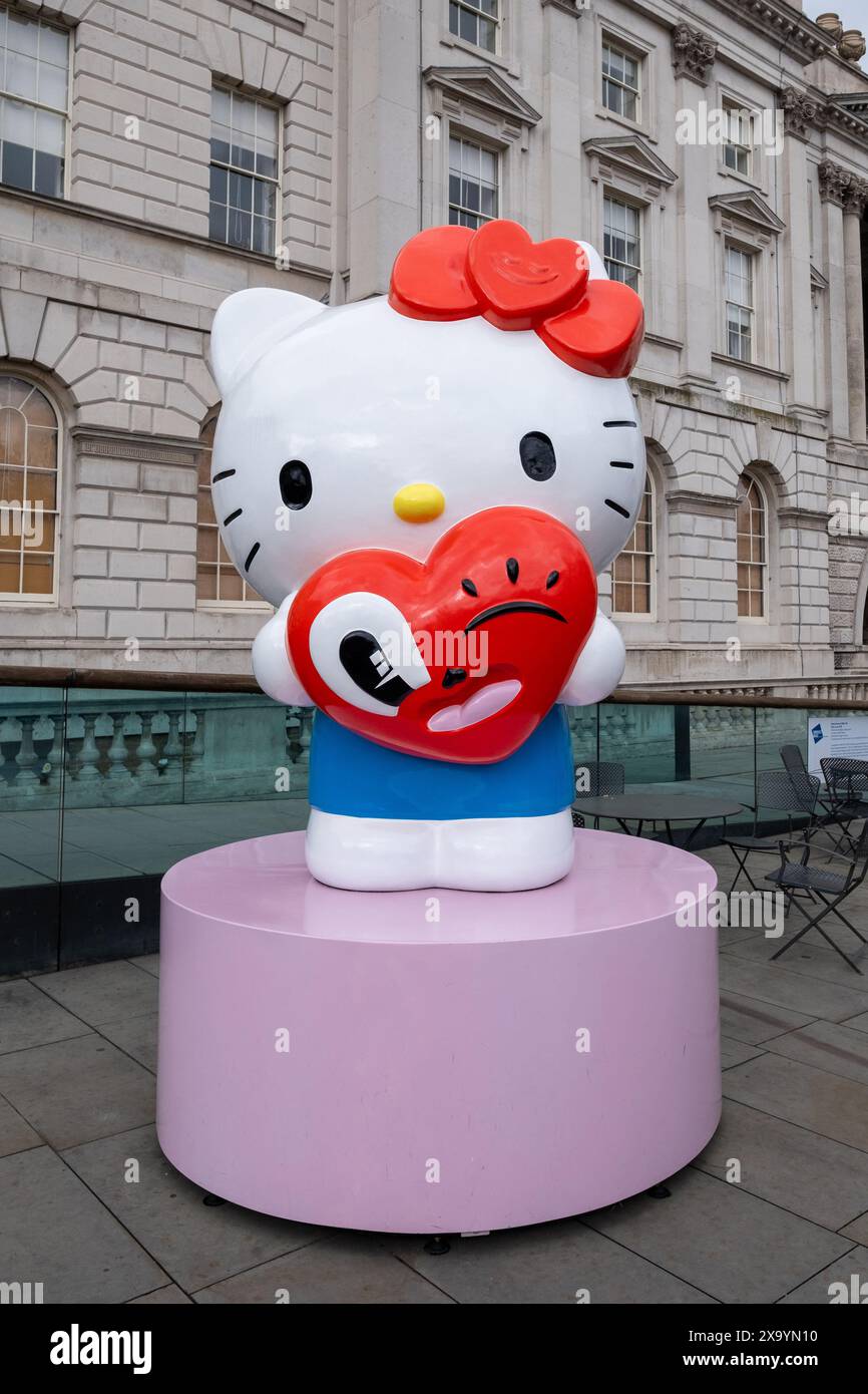 Eine Hello Kitty-Statue mit rotem Herzballon vor einem Gebäude in London, Großbritannien Stockfoto