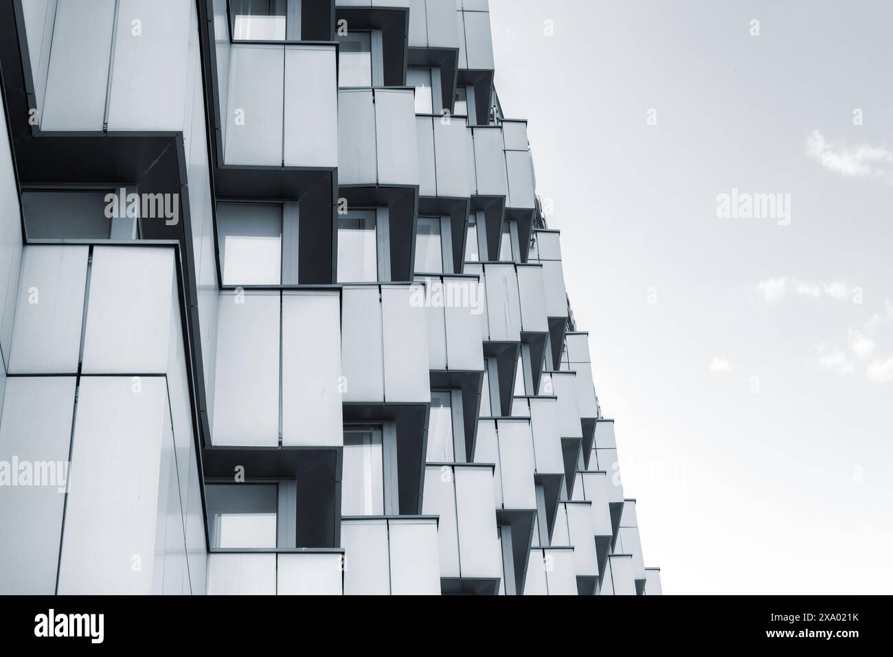 Abstrakte Hintergrundfoto moderner Architektur, Eckmuster, Wände mit Edelstahlpaneelen und glänzenden Fenstern. Blauer Farbfilter Stockfoto