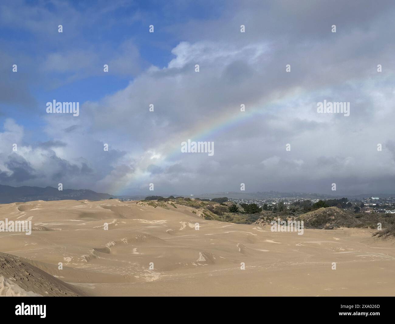Ein Regenbogen über der abgeholzten Düne in der Wüstenlandschaft Stockfoto