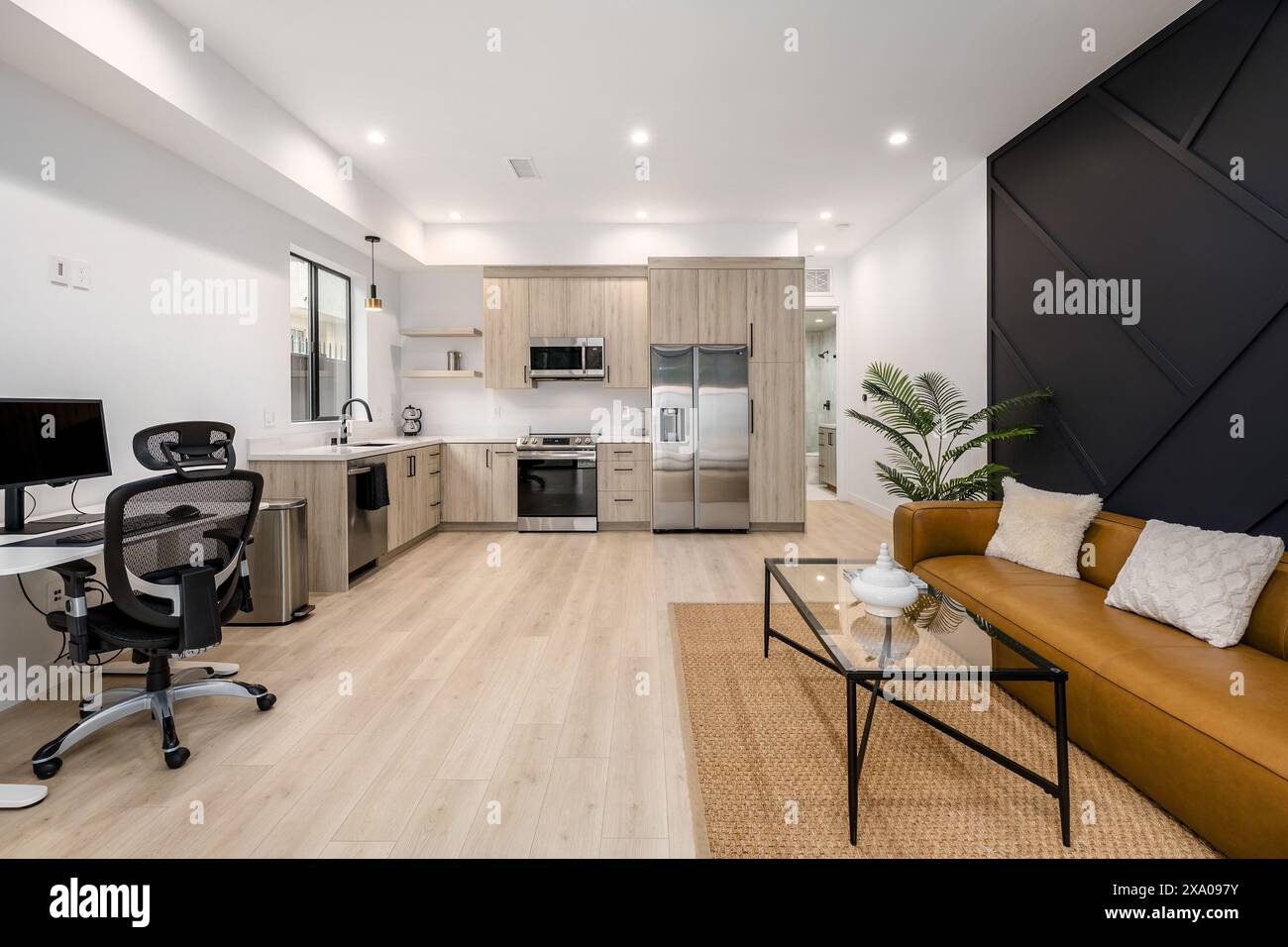 Modernes Wohnzimmer mit gelbem Sofa und weißem Essgarnitur Stockfoto