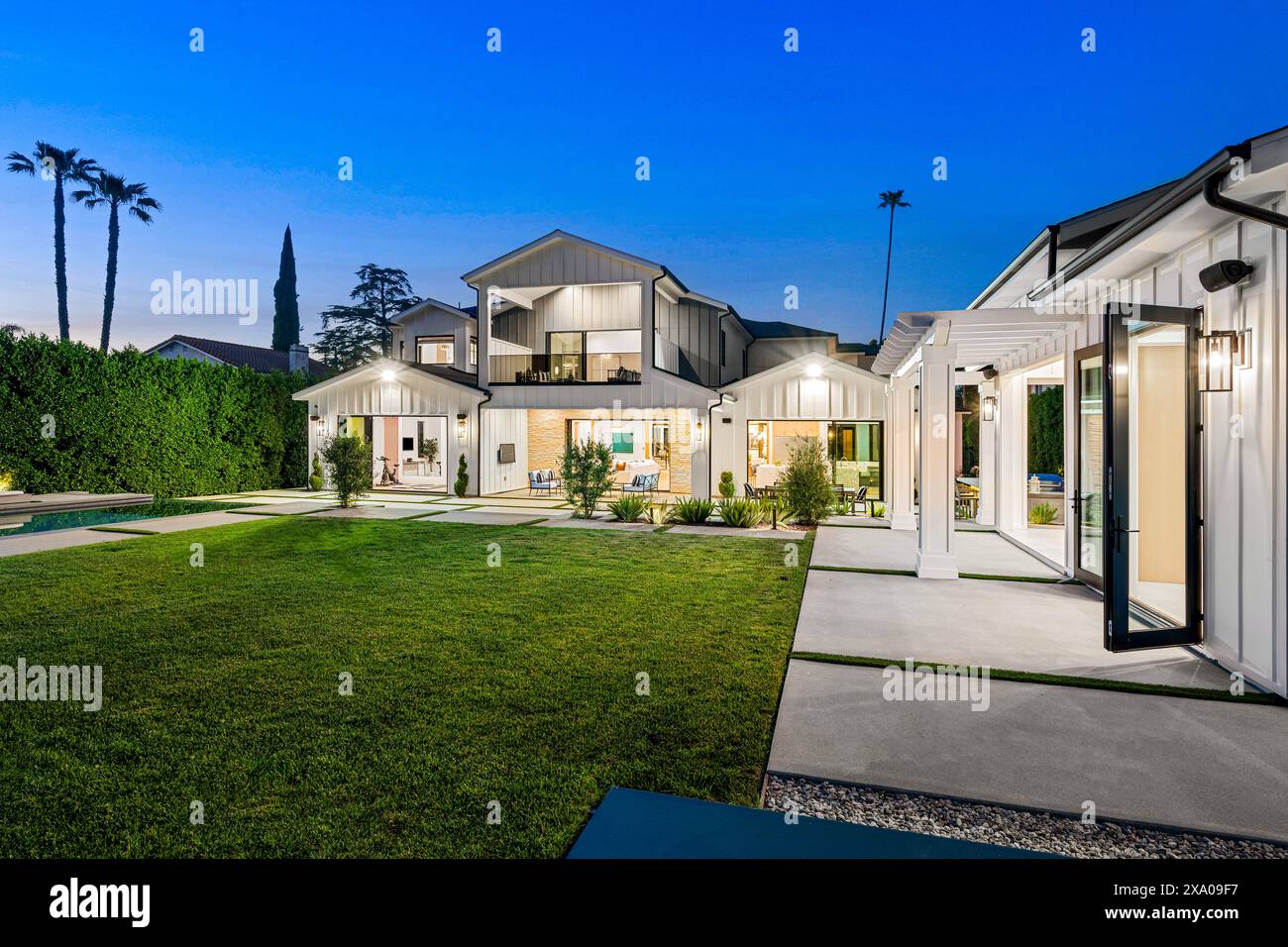Ein Hinterhof mit üppig grünem Gras und zwei Swimmingpools auf jeder Seite Stockfoto