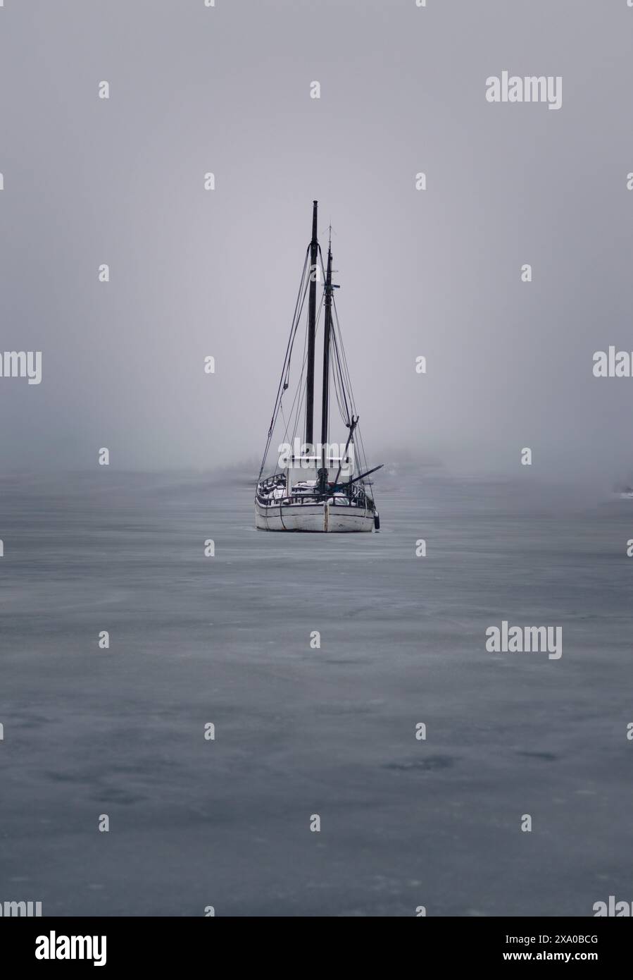 Die vertikale eines Segelbootes, das an einem bewölkten Tag im offenen Wasser segelt Stockfoto