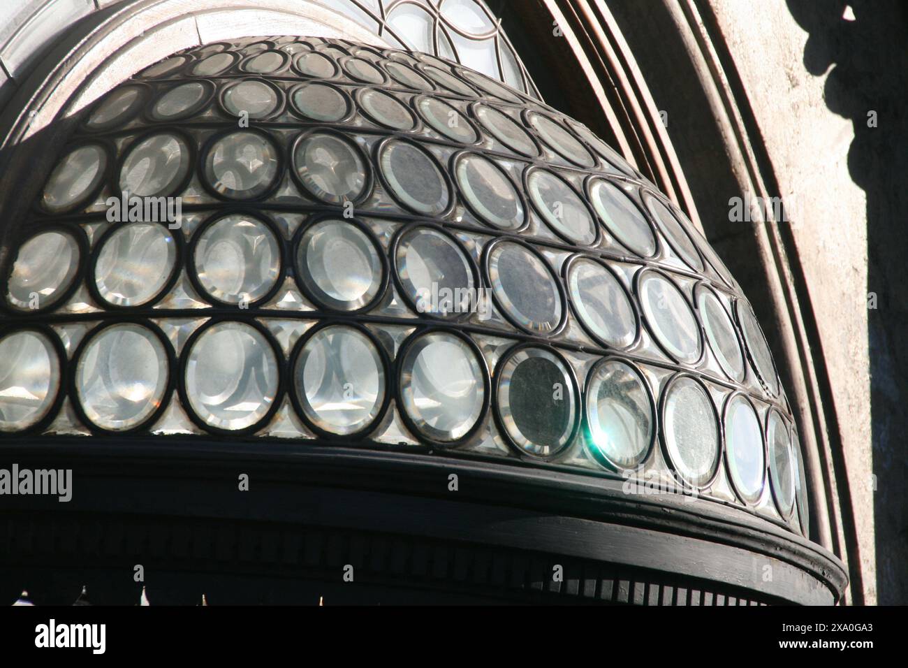 Eine Glaskuppel befindet sich auf einem großen Gebäude und schafft eine majestätische Silhouette am Himmel Stockfoto