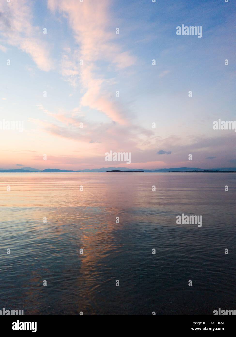 Meerblick in Glyfada, Griechenland bei Sonnenuntergang, Abendzeit. Wolkenspiegelung im stillen Meer Stockfoto