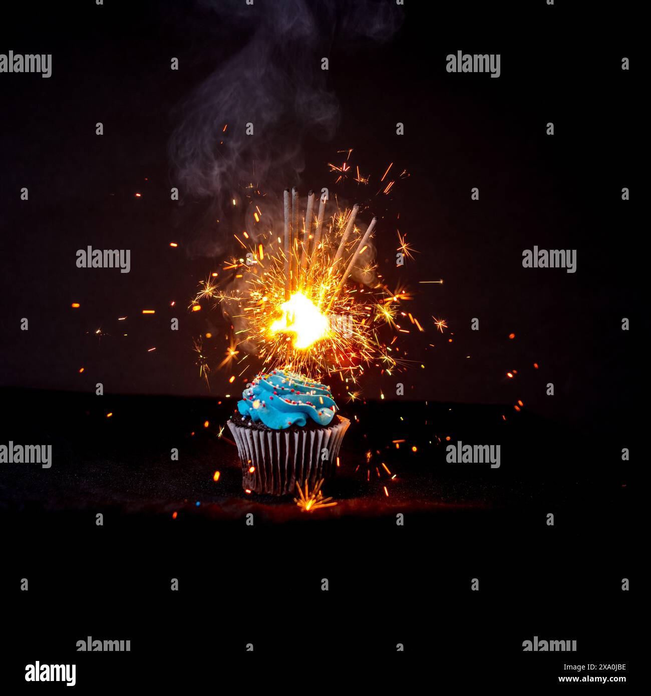 Ein Cupcake, der im Dunkeln von einem Feuerwerk beleuchtet wird Stockfoto