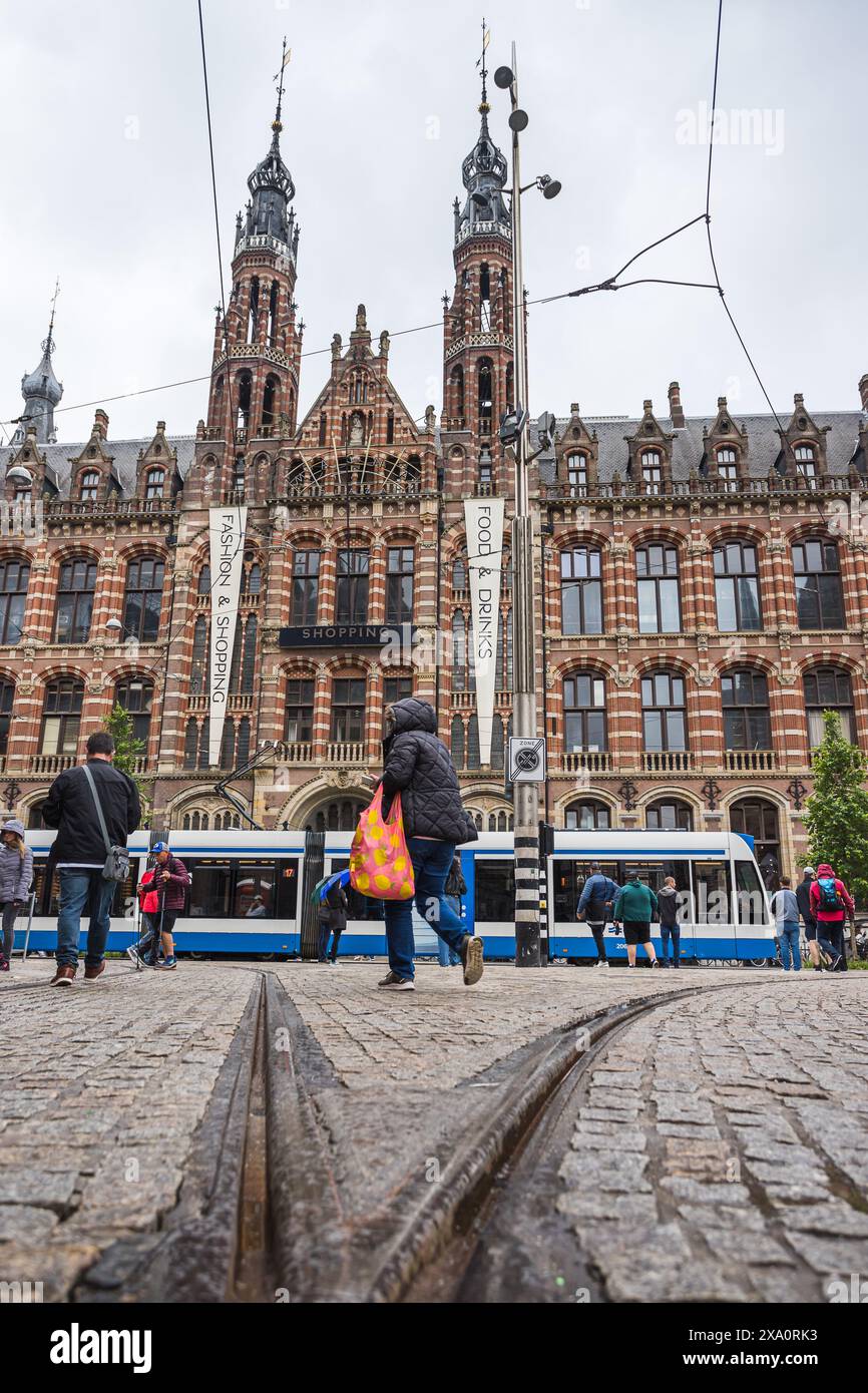 Shopper werden neben einer Straßenbahn unter dem Magna Plaza in Amsterdam, Niederlande, abgebildet. Am 29. Mai 2024 wurde dieses atemberaubende Gebäude im neogotischen Stil aufgenommen Stockfoto