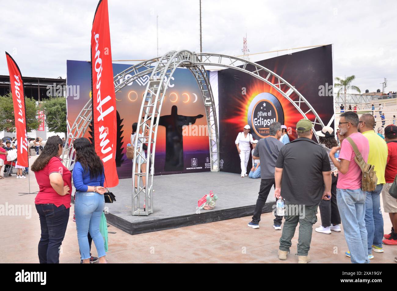 Die Zuschauer treffen sich in der Nähe von Bannern im Freien, während zwei Personen auf der Bühne tanzen Stockfoto
