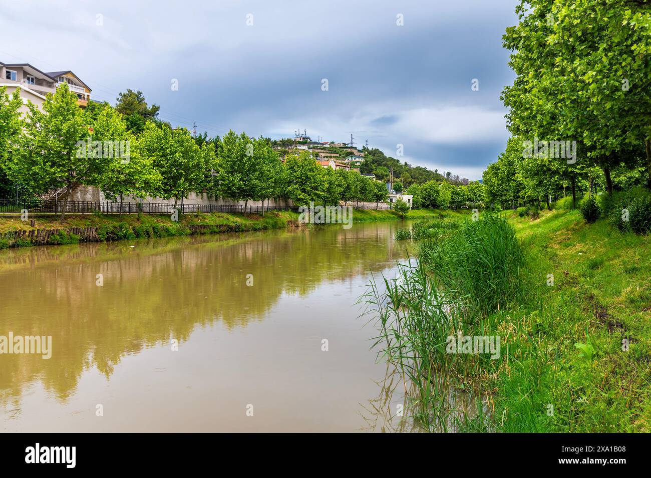 Ein Blick entlang des Flusses drin in Richtung von einer Fußgängerbrücke in Lezhe, Albanien im Sommer Stockfoto