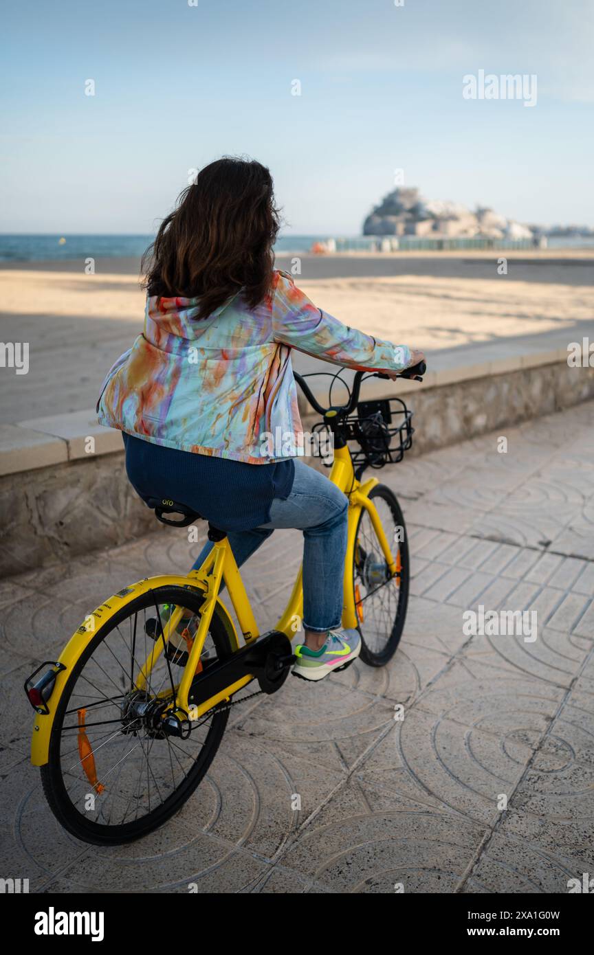 Frau fährt Fahrrad entlang der Promenade, Peñiscola, Spanien Stockfoto