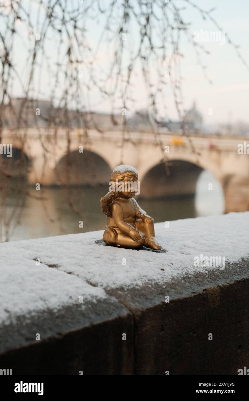 Eine kleine Engelsstatue am Flussufer Stockfoto