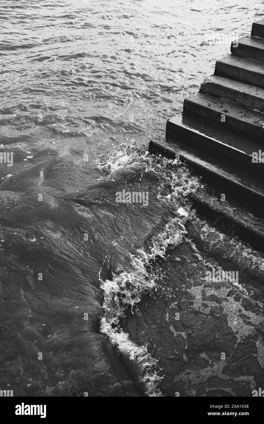 Ein einfarbiges Bild einer Treppe, die in das Wasserj führt Stockfoto