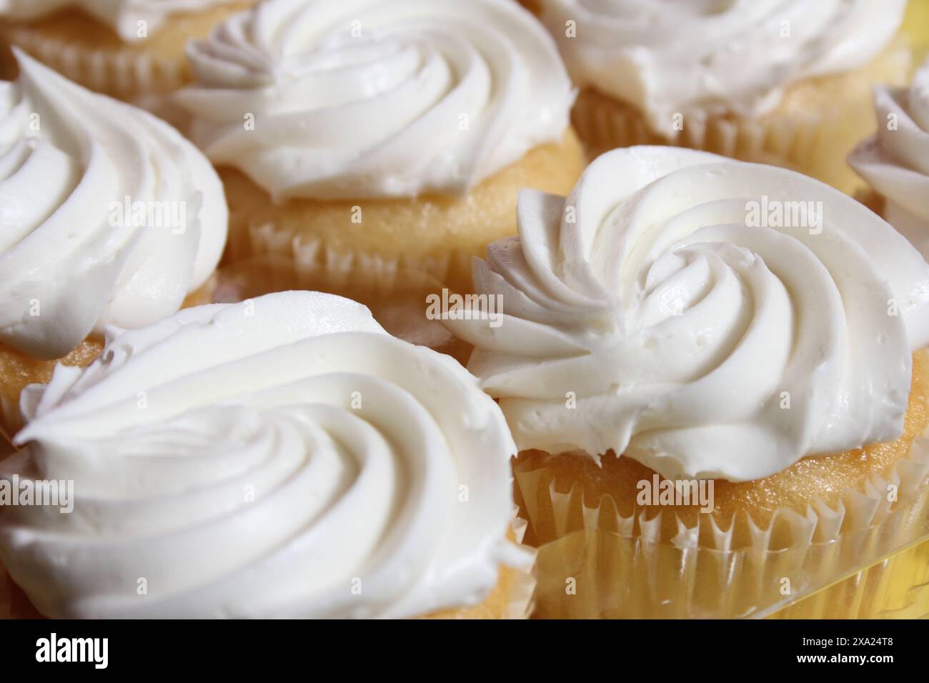 Die köstlichen Cupcakes mit cremiger weißer Glasur wirbeln Stockfoto