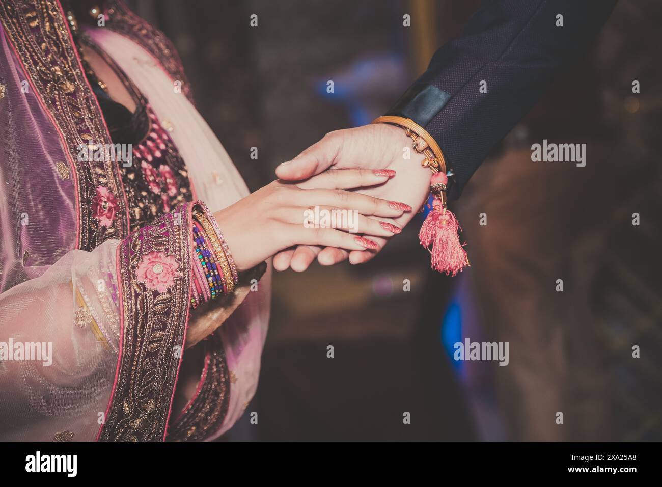 Eine Nahaufnahme von Braut und Bräutigam, die Hände halten, symbolisiert Liebe und Freundschaft Stockfoto