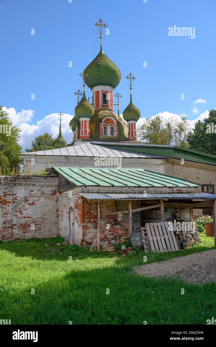 Hof mit einer Scheune mit alten Ziegelmauern auf dem Hintergrund von Kuppeln und Kreuzen der mittelalterlichen Kathedrale von Vladimir Ikone der Gottesmutter in Pereslav Stockfoto