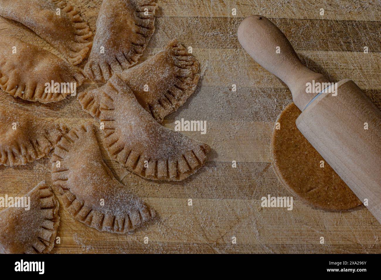 Kuchenteig auf einem Schneidebrett ausrollen Stockfoto