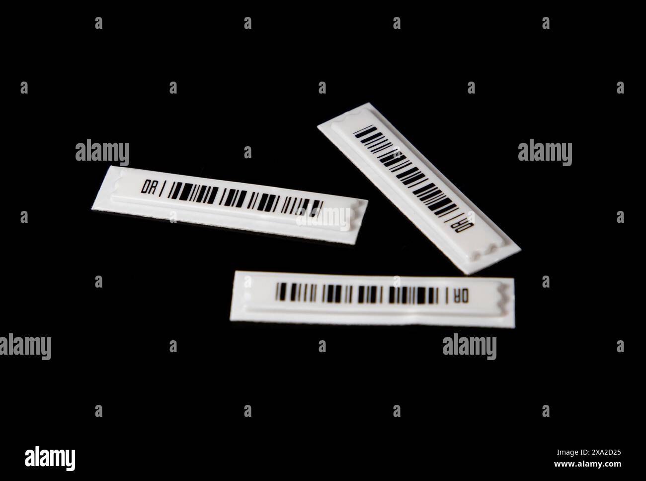 Die magnetischen Strichcode-Etiketten für den Diebstahlschutz auf schwarzem Hintergrund. Stockfoto