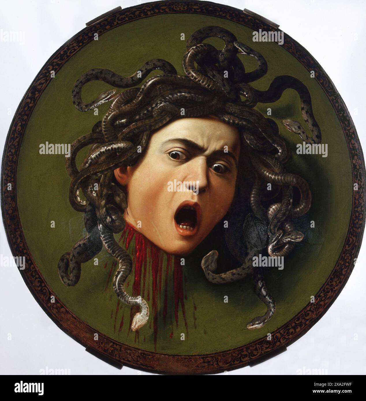 Italien: Medusa als Schild der Athene. Öl auf Leinwand Gemälde von Michelangelo Merisi da Caravaggio (29. September 1571 - 18. Juli 1610), c. 1597. In der griechischen Mythologie war Medusa (griechisch: Μέδουσα, 'Hüterin, Schutzin') eine Gorgon, ein chthonisches Monster und eine Tochter von Phorcys und Ceto. Direkt auf sie zu blicken, würde Zuschauer zu Stein machen. Sie wurde von dem Helden Perseus enthauptet, der ihren Kopf danach als Waffe benutzte, bis er ihn der Göttin Athene gab, um ihn auf ihren Schild zu setzen. In der klassischen Antike erschien das Bild des Kopfes der Medusa in der böswilligen Abwendung als Gorgoneion bekannt. Stockfoto