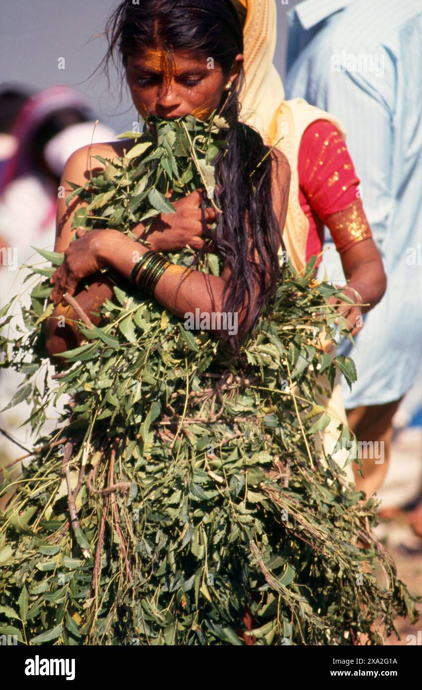 Indien: Ein Verehrer der Göttin Yellamma, bedeckt mit Neemblättern, Poornima Festival in der Nähe des Yellamma-Tempels in Saundatti, Karnataka (1994). Jedes Jahr im Hindumonat Magh (Januar bis Februar) versammeln sich mehr als eine halbe Million Menschen um den winzigen Tempel der Göttin Yellamma in Saundatti. Yellamma ist der Schutzpatron der devadasi oder Frauen, die dem Dienst an einer Gottheit oder einem Tempel gewidmet sind. Stockfoto