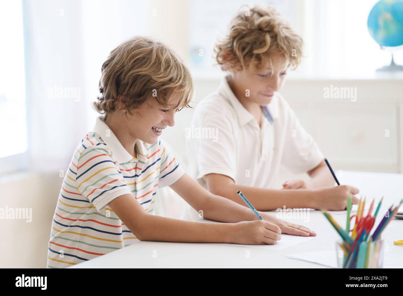 Kind in der Schule. Schüler in der Klasse. Junge macht Hausaufgaben. Hausschulunterricht oder Studienunterstützung. Junge, der Mathe-Aufgaben macht. Grundschüler Stockfoto