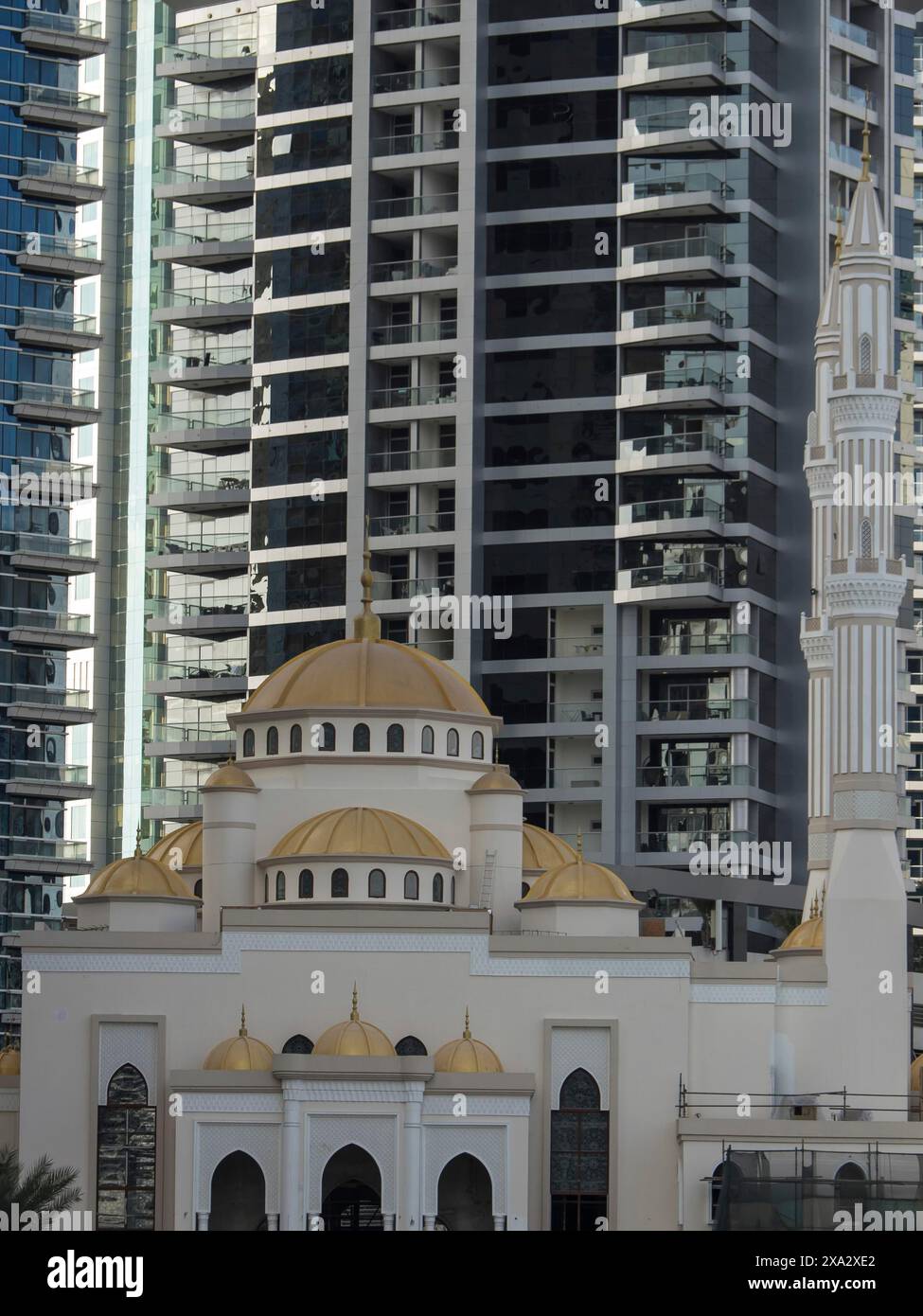 Eine Moschee mit goldenen Kuppeln vor dem Hintergrund moderner Wolkenkratzer an einem sonnigen Tag, dubai, arabische emirate Stockfoto