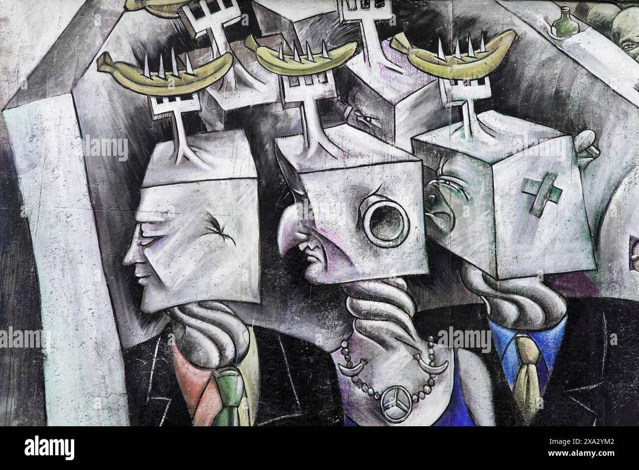 Graffiti an der Berliner Mauer in der East Side Gallery, Berlin, Deutschland, Europa, surrealistische Kunstwerke mit futuristischen, maskierten Köpfen und gelben Bananen Stockfoto