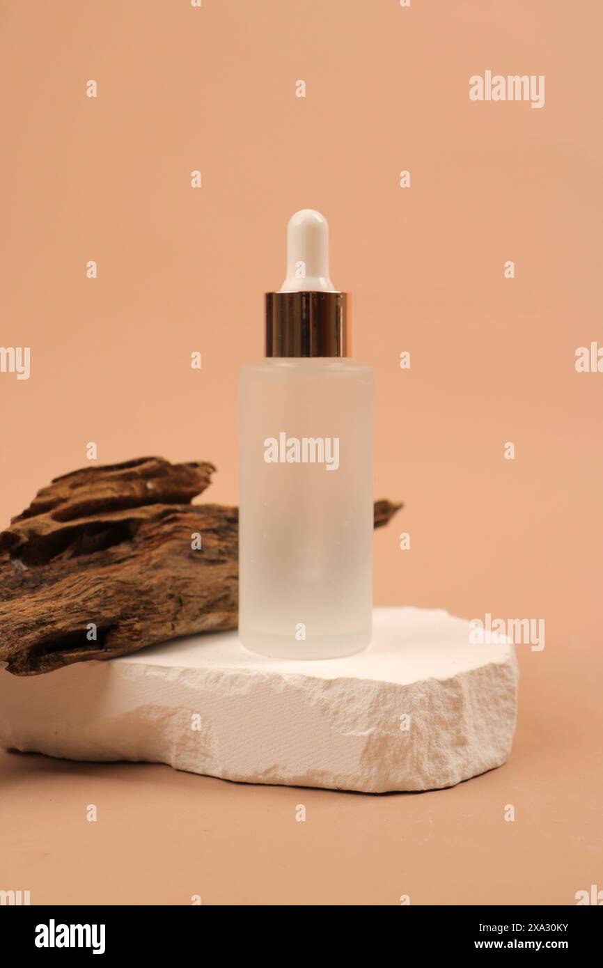 Elegante einzelne Tropfflasche mit Hautpflege auf minimalistischem Hintergrund Stockfoto