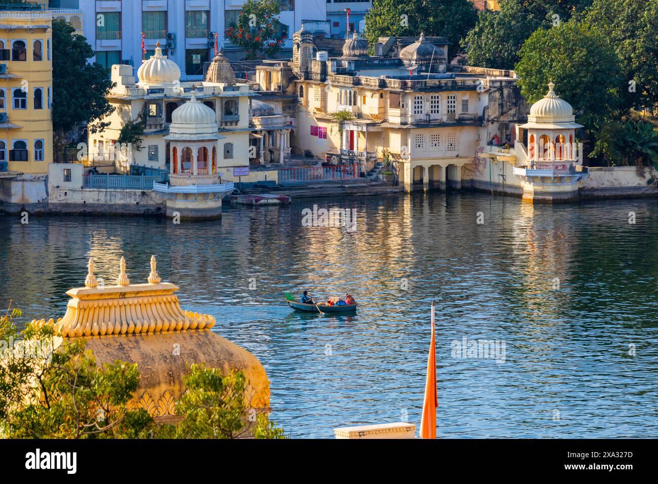 Touristenboot auf dem See Pichola mit dem Stadtpalast im Hintergrund, Udaipur, Rajasthan, Indien, Südasien. Stockfoto