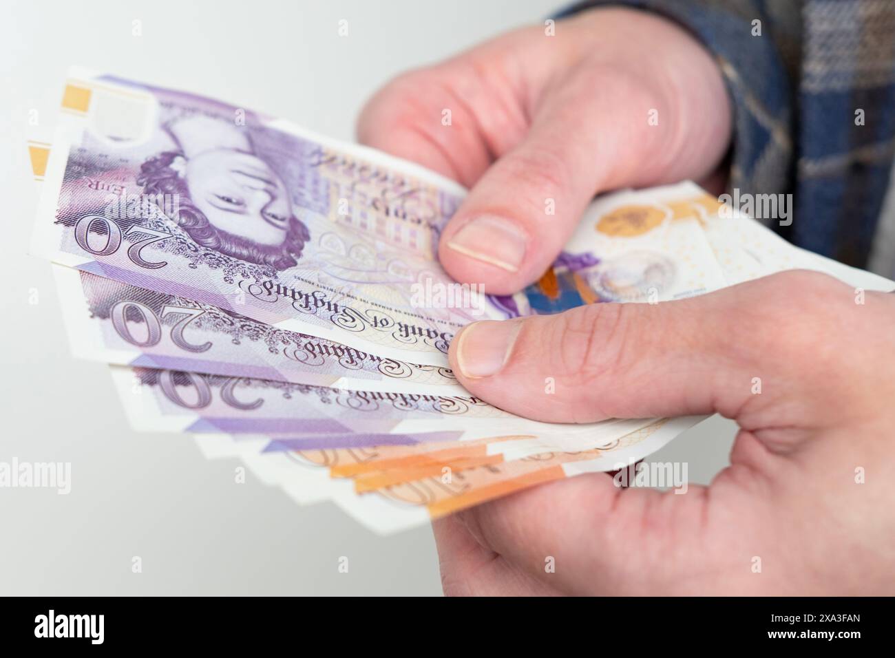 Männliche Hände, die Geld halten, englische Pfund Sterling-Rechnungen zählen, sich über den Erfolg freuen, voraussehen, was sie ausgeben sollen, fördern gutes Finanzverhalten, Stockfoto