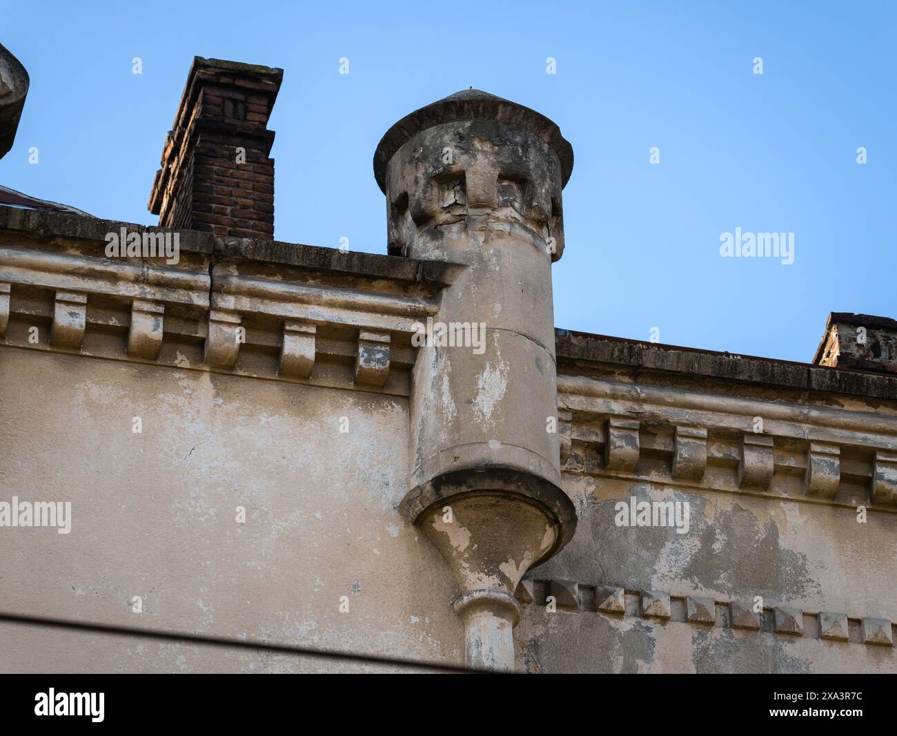 Turm und gemauerter Kamin auf dem Dach eines alten Hauses. Stockfoto