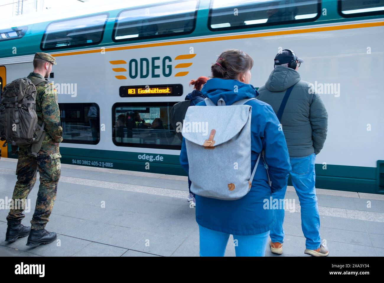 Regionalzug kommt am Berliner Bahnhof an, Passagiere, Militär im Urlaub warten auf Bahnsteig, Verspätung der öffentlichen Verkehrsmittel, tägliche Pendelfahrt, Berlin - April Stockfoto