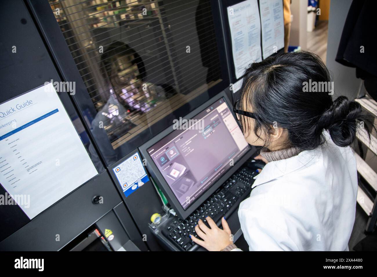 Frau, die an einem modernen medizinischen Gerät mit Monitor und Tastatur arbeitet Stockfoto