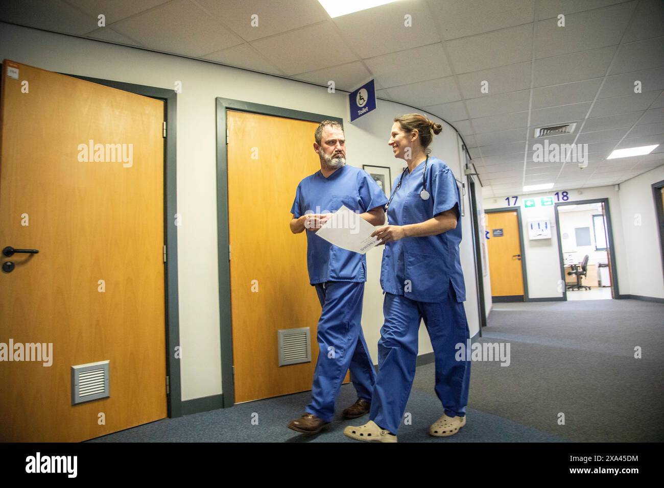 Medizinisches Personal läuft durch einen Krankenhausflur, Großbritannien Stockfoto