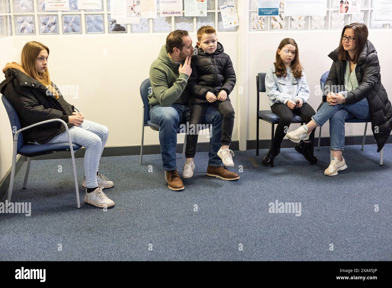 Familie wartet im Sitzbereich einer Arztpraxis Stockfoto