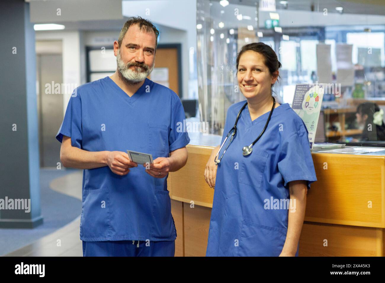 Medizinische Fachkräfte, die an der Rezeption einer Arztpraxis in Großbritannien stehen Stockfoto
