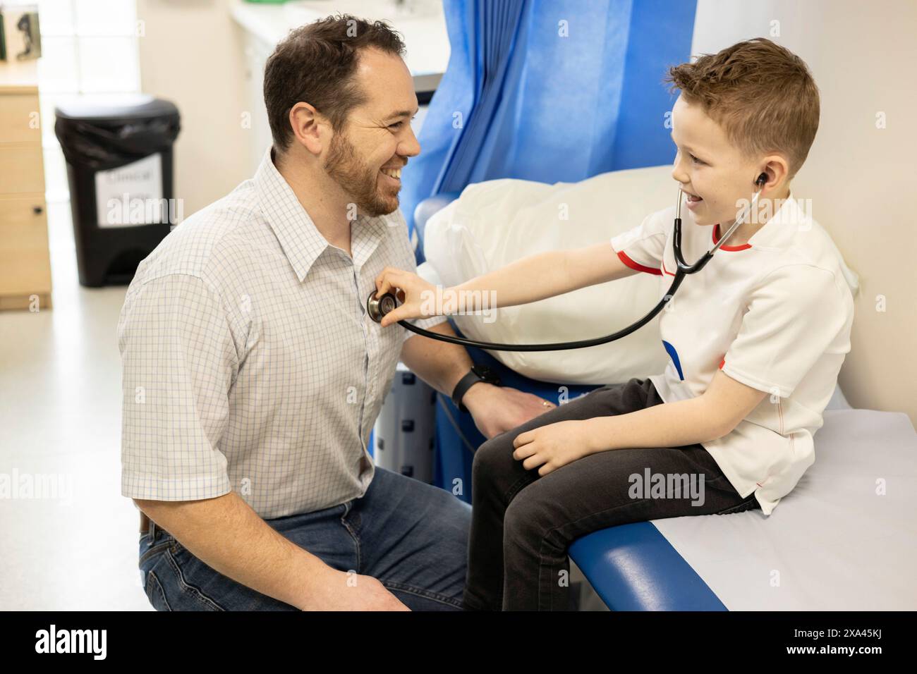 Kind spielt Arzt mit erwachsenem Arzt in einer Klinik Stockfoto