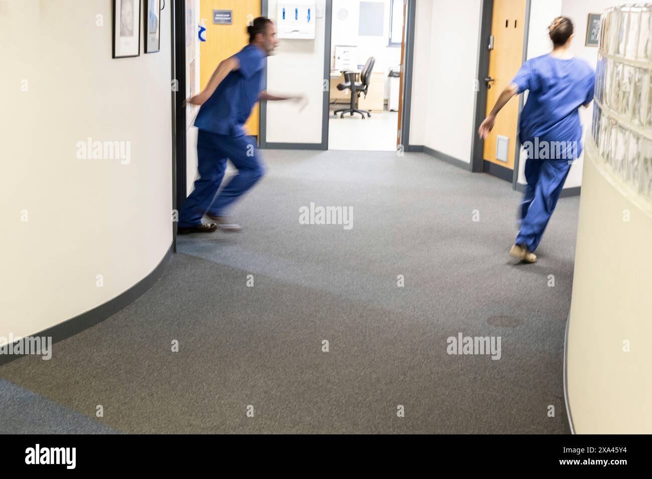 Medizinische Fachkräfte, die in einem Klinikkorridor einer Arztpraxis arbeiten Stockfoto