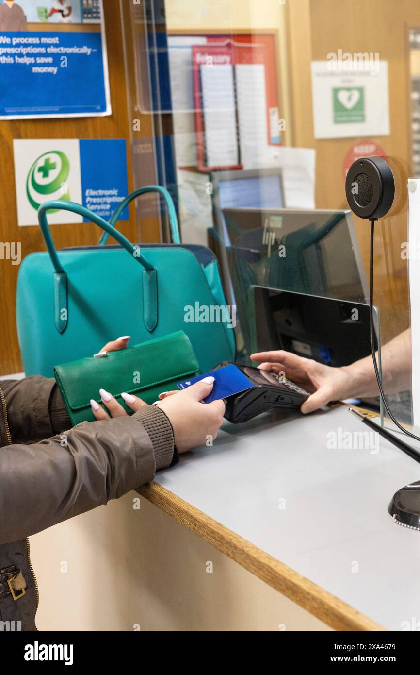 Eine Person, die eine Zahlung an einer Rezeption eines Krankenhauses leistet Stockfoto