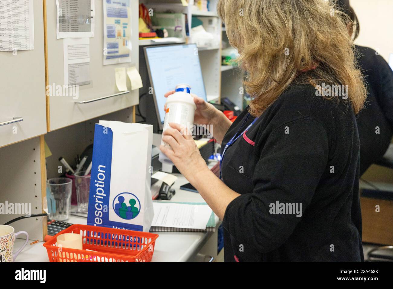 Apotheker untersucht eine Medikamentenflasche am Arbeitsplatz. Stockfoto